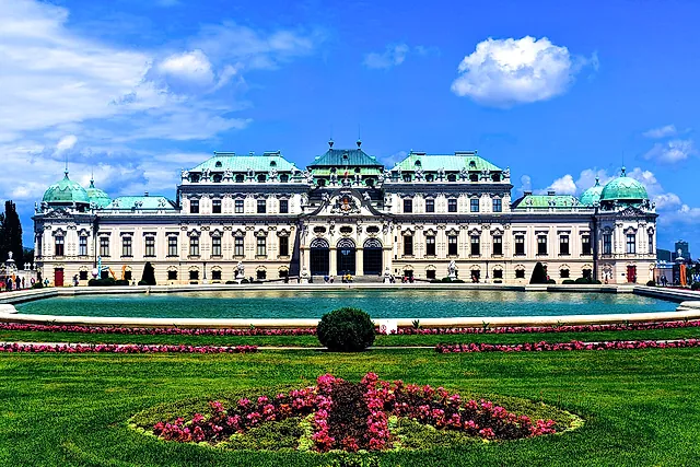 The Upper Belvedere under a blue sky, with the pond and flower beds