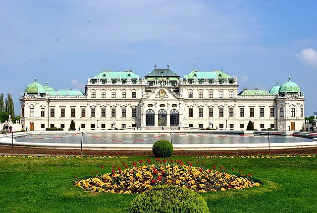 The Upper Belvedere behind the pond and a bed of yellow flowers