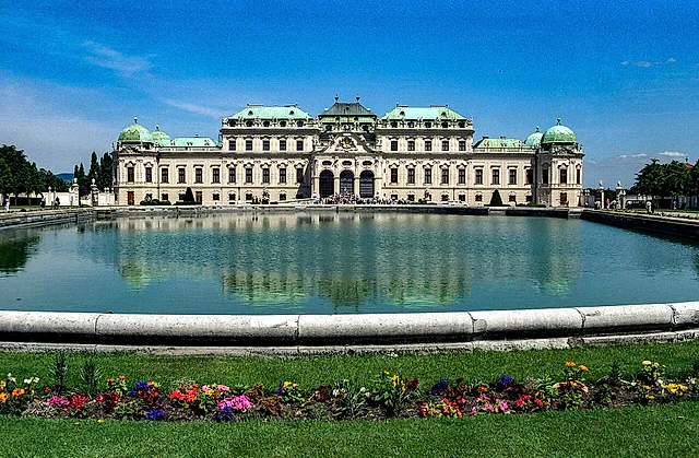 The Upper Belvedere reflected in its pond, with flower beds in the foreground